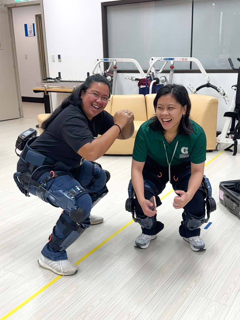 two students trying on assistive technology for farmers