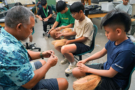 H. Larry Raigetal teaches 4-H participants how to make rope from dried coconut husks