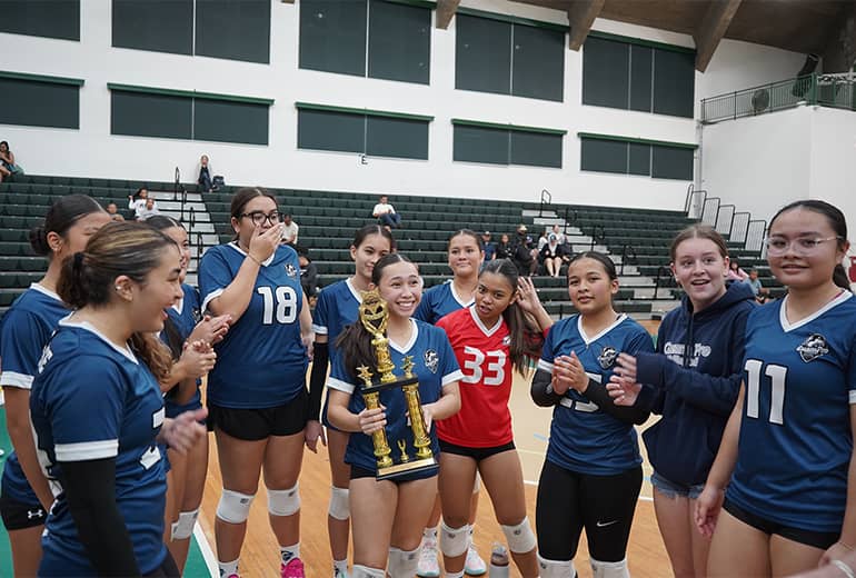 team huddles up around Guam Pro 1 3rd place winner holding trophy