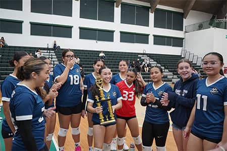 team huddles up around Guam Pro 1 3rd place winner holding trophy