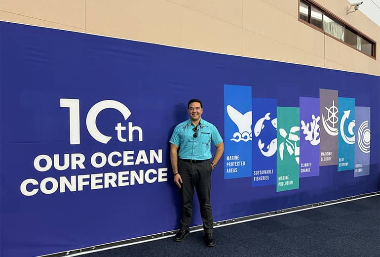 Austin Shelton poses in front of “10th Our Ocean Conference” sign in Busan, South Korea