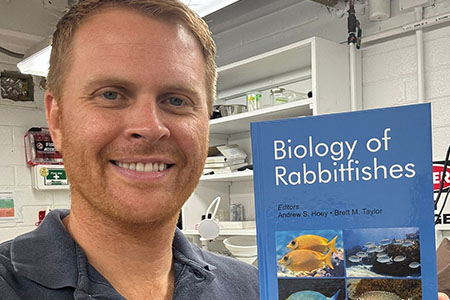 Dr. Brett Taylor holding the Biology of Rabbitfishes book