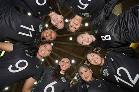 upward angle of lady tritons huddled for a photo