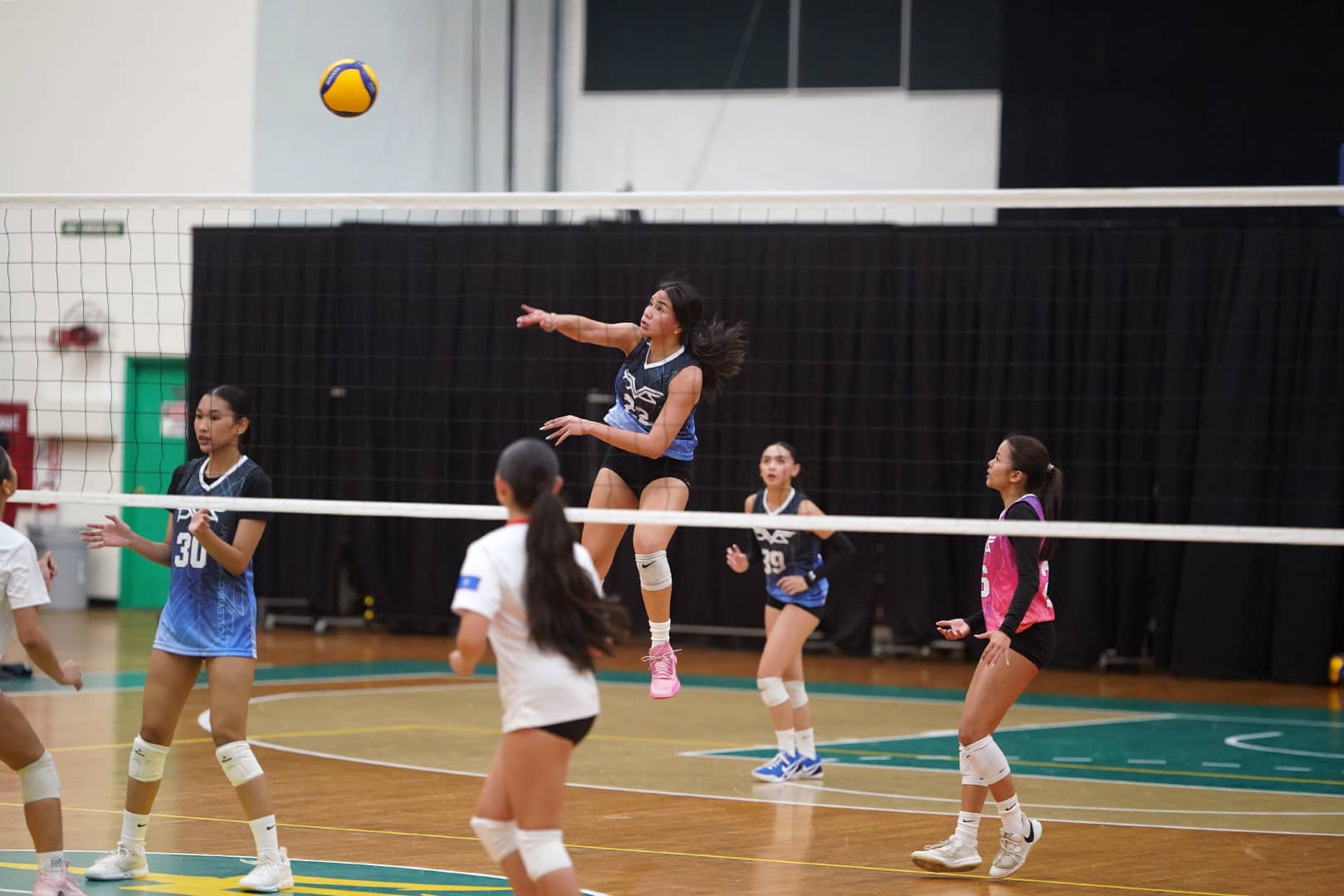 Lea Aromin spiking a volleyball
