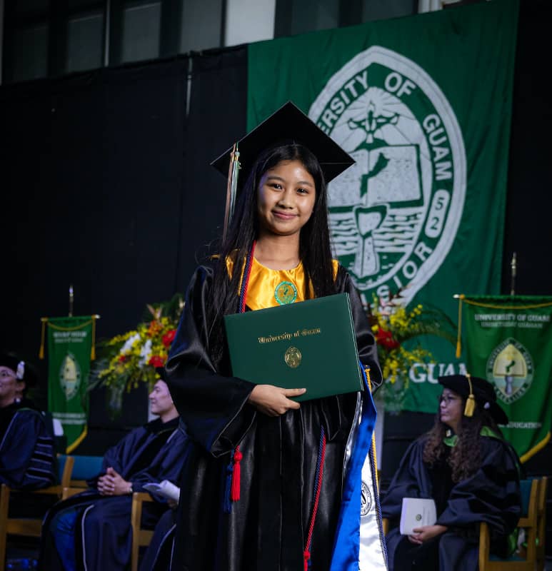 Frances Pakingan holds up her diploma during the Fanuchånan (Fall) 2025 Commencement Ceremony.