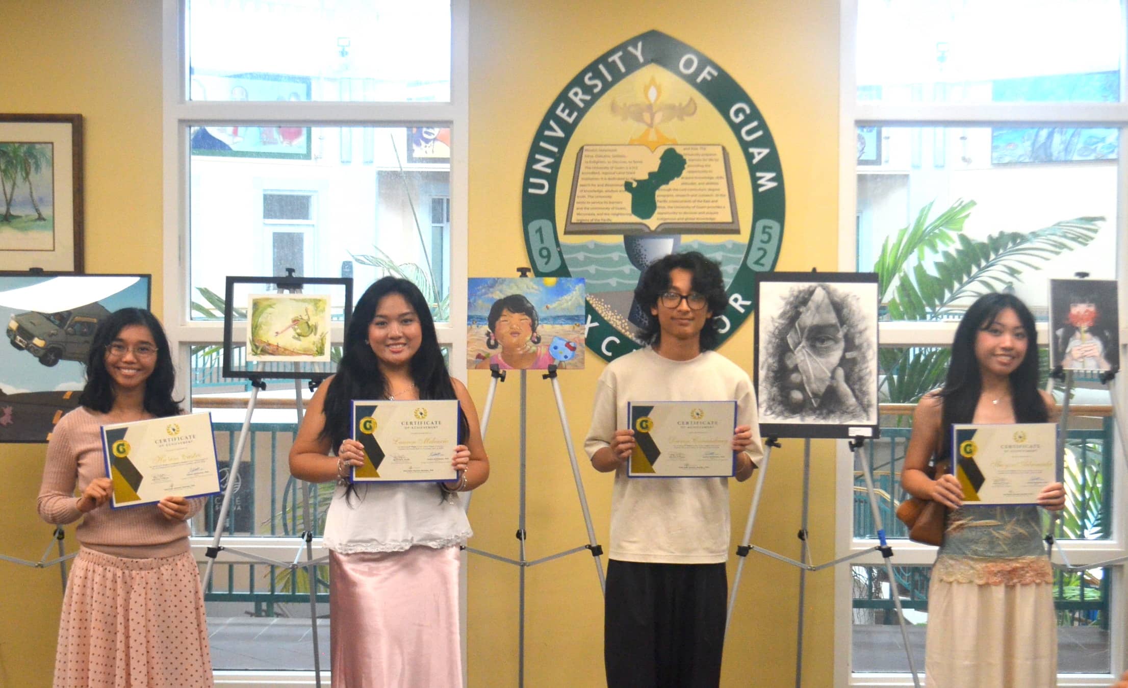 The winners of the Tritons Night of the Arts art exhibit stand with their winning pieces