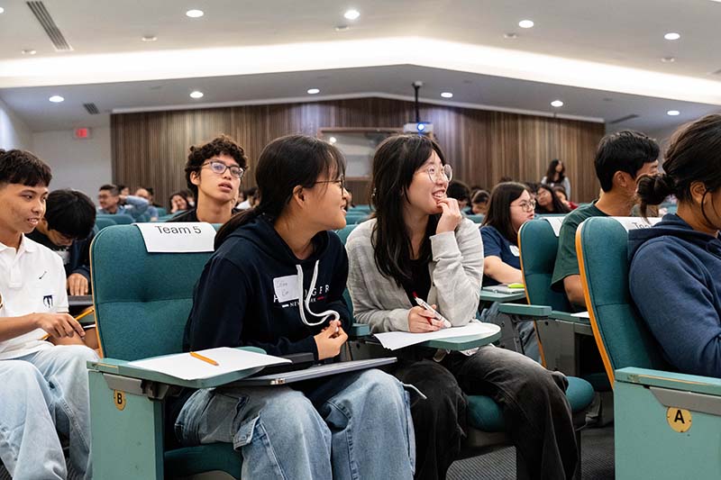 Two girls laughing with papers and pencils in front of them