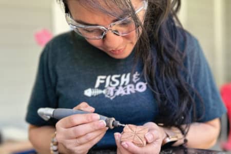 University of Guam alumna Sarah Taitano blends art, culture, and care through More Art x Less War, a Pacific Islander lifestyle brand rooted in mixed media, indigenous identity, and social justice. Drawing from her background in social work and mental health advocacy, Taitano uses creativity as a form of healing, connection, and purposeful change.