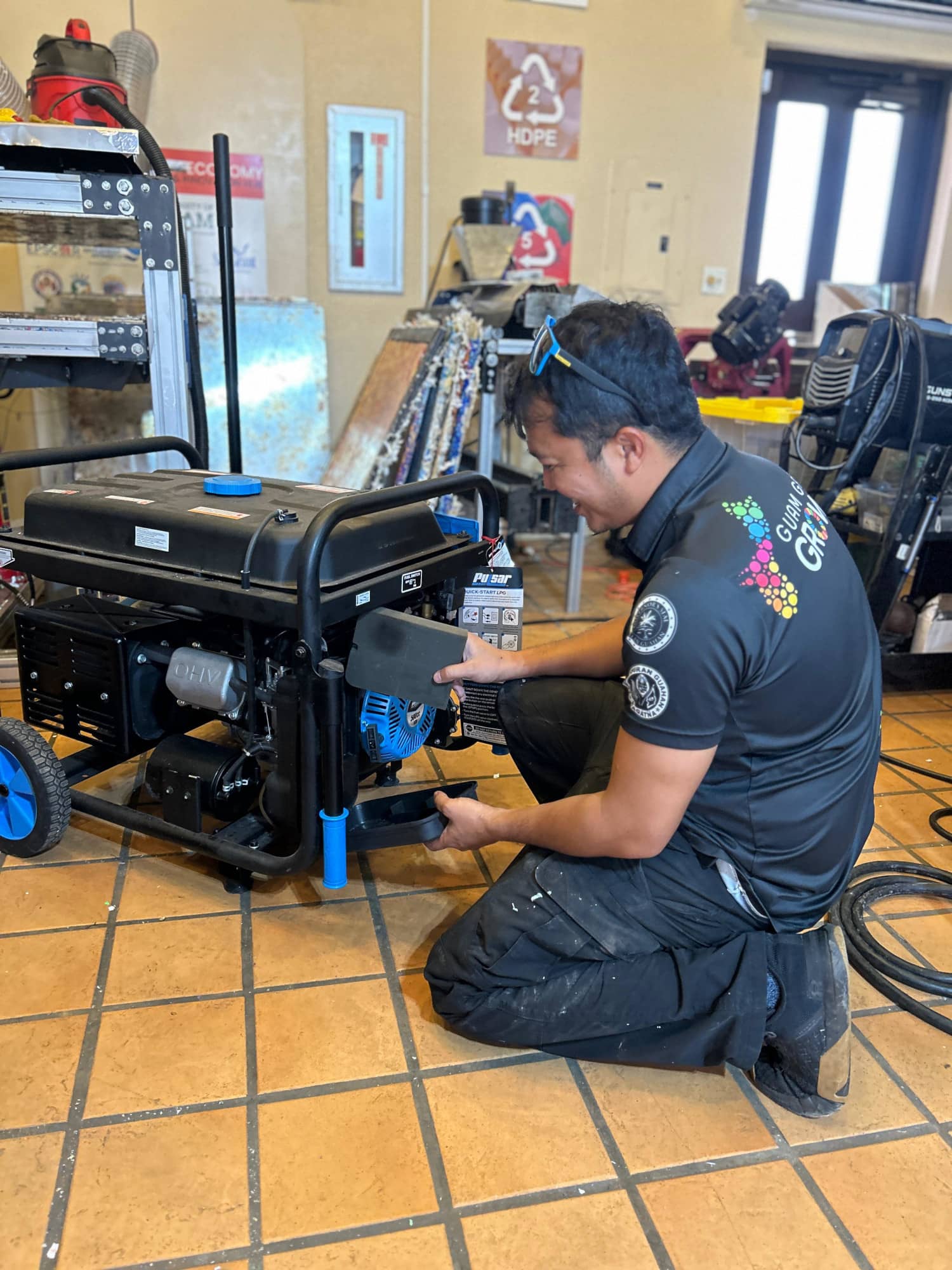 Justin Cruz services a generator at the Hagatna campus.
