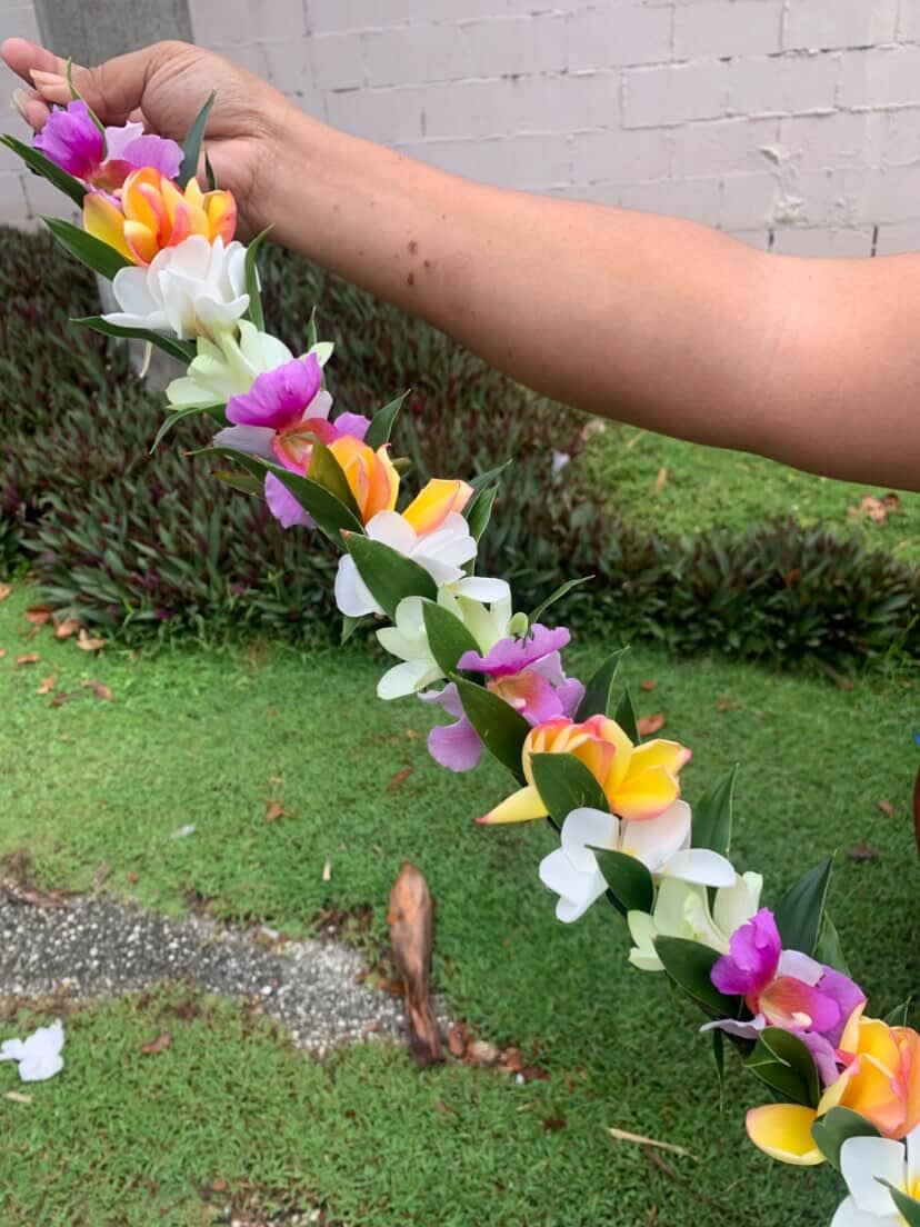 Elizabeth Rutun holds up a lei