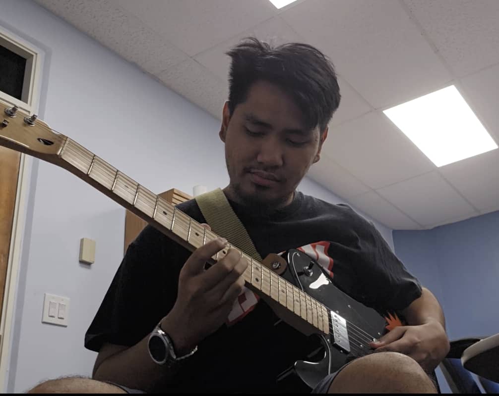 Emann Adonay plays the guitar