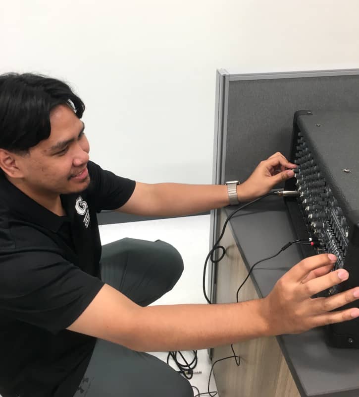 Emann Adonay inspects a sound mixer