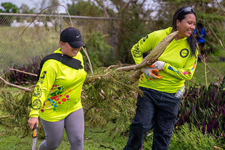 G3 Conservation Corps members clear tree debris on UOG campus