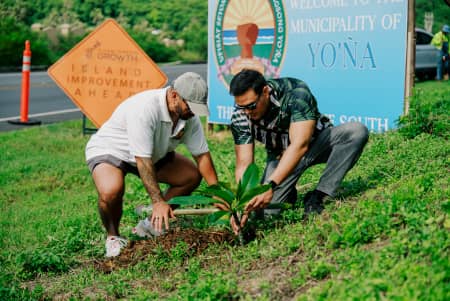 Austin Shelton Ph.D. and Mayor BJ Terlaje work together to plant a plumeria along the cliff side