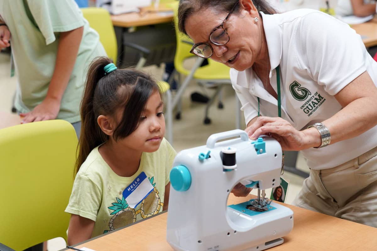 Girl learning how to use a sewing machine