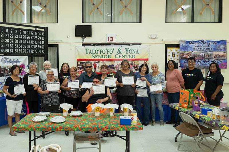 Bingocize participants flaunt their certificates after the final session on Oct. 4, 2026, at the Yona/Talo’fo’fo’ Senior Center. A group of older adults holding Bingocie certificates and posing for a group photo