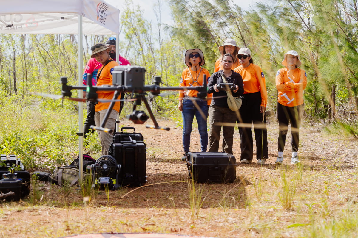 Drone Corps members observe a drone mid-flight