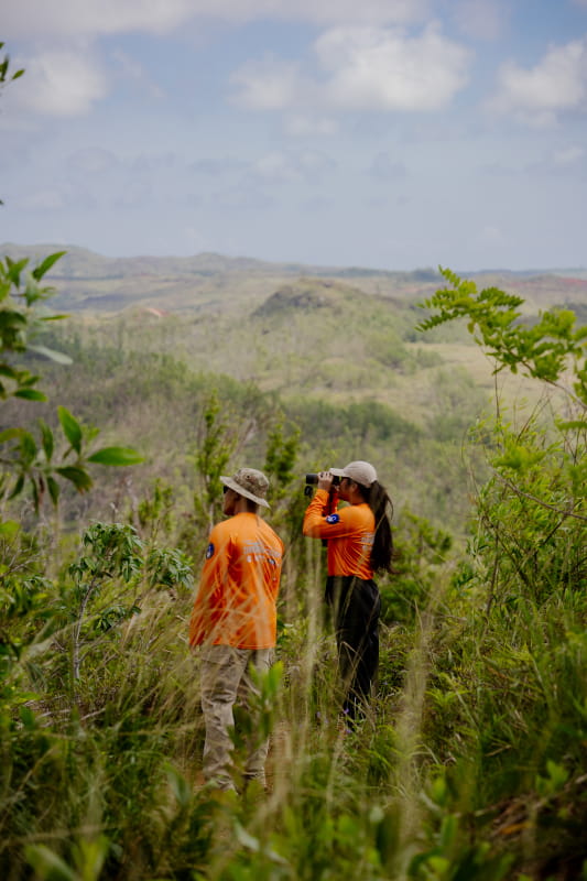Michael Baco and Patricia Servito serve as visual observers during a drone survey mission