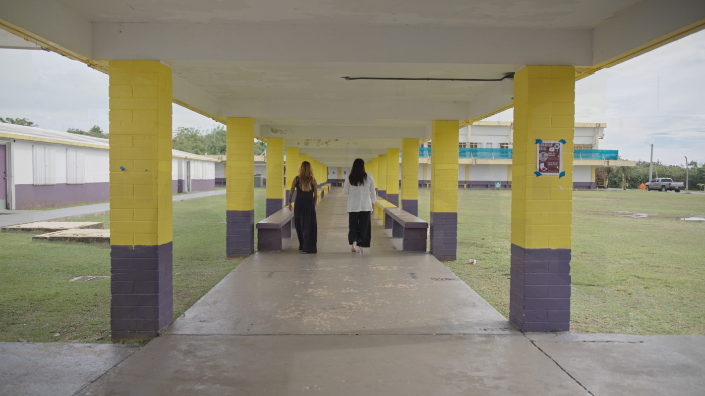 Two women walking down a school hallway