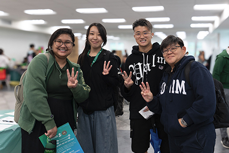 Group photo of four students during campus welcome event.